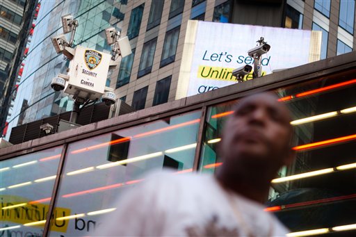 A pedestrian passes under the watchful eyes of surveillance cameras in Times Square in New York, Tuesday, Aug. 19, 2011. Since the terrorist attacks of Sept. 11, 2001, the New York Police Department has become one of the country's most aggressive domestic intelligence agencies, one that operates far outside its borders and targets ethnic communities in ways that would be prohibited for the federal government. (AP Photo/John Minchillo) (AP)