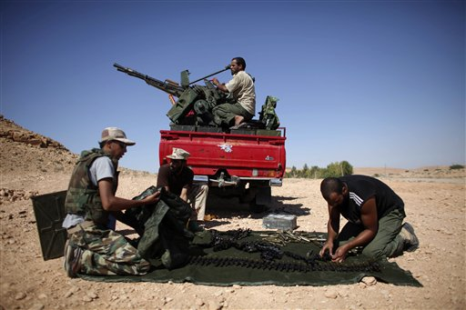 Former rebel fighters prepare an anti-aircraft weapon near the entrance of Bani Walid, Libya, Sunday, Sept. 11, 2011