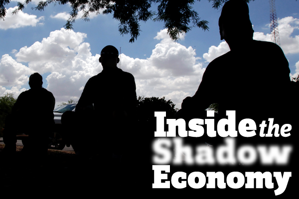 Day laborers sit in a parking lot in Phoenix. (AP/Matt York)