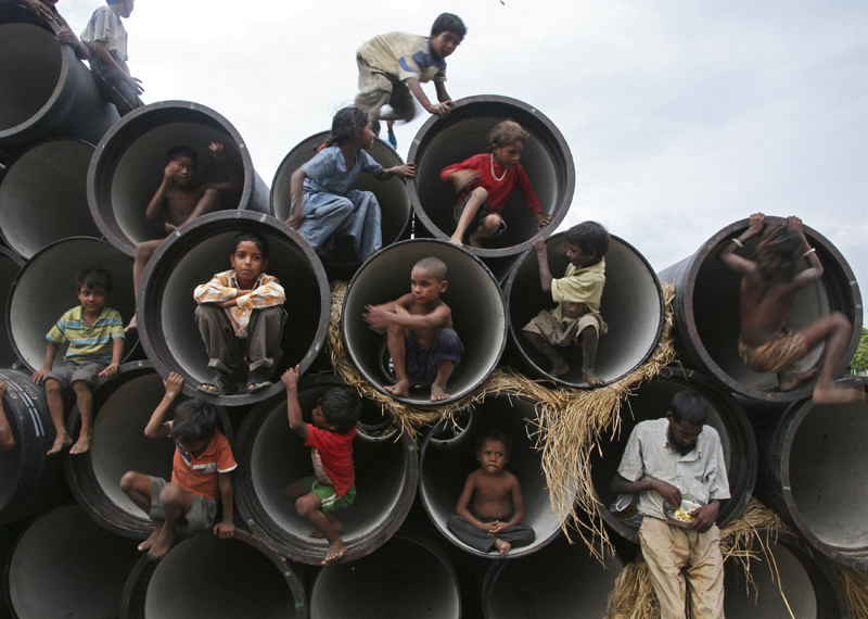 Children play in water pipes at a construction site on the banks of the Yamuna River in the northern Indian city of Allahabad July 26, 2010. REUTERS/Jitendra Prakash (INDIA - Tags: SOCIETY IMAGES OF THE DAY) (Â© Jitendra Prakash / Reuters)