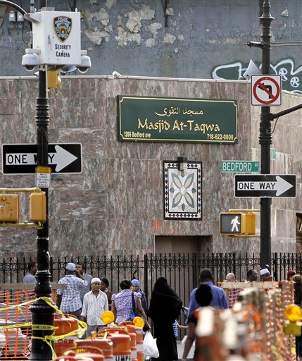In this photo made Aug. 18, 2011, people pass below a New York Police Department security camera, upper left, which is above a mosque on Fulton St., in the Brooklyn neighborhood of Bedford-Stuyvesant in New York. The New York Police Department collected intelligence on more than 250 mosques and Muslim student groups in and around New York, often using undercover officers and informants to canvas the Islamic population of Americas largest city, according to officials and confidential, internal documents obtained by The Associated Press.(AP Photo/Bebeto Matthews) (AP)