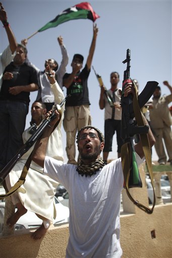 Rebel fighters celebrate, as negotiations resumed between tribal elders and rebel leaders in a mosque at a checkpoint between Tarhouna and Bani Walid, Libya, Tuesday, Sept. 6, 2011.  A large convoy of Libyan soldiers accompanied by Tuareg tribal fighters are reported to have moved towards the capital of neighboring Niger, although it is not clear of Gadhafi family members were among the heavily armed group, according to a report Tuesday from Abdoulaye Harouna, owner of the Agadez Info newspaper. (AP Photo/Alexandre Meneghini) (AP)