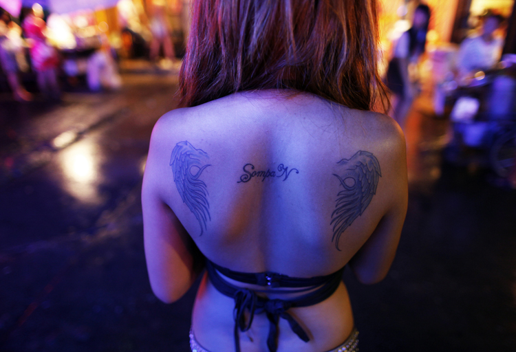 A Thai go-go dancers waits for customers at Bangkok's normally packed Soi Cowboy red-light area just before curfew May 25, 2010. Bar owners and go-go dancers say a night-time curfew in the Thai capital has badly affected their business, with tourist scared off and expatriate customers staying home.   REUTERS/Damir Sagolj (THAILAND - Tags: POLITICS CIVIL UNREST TRAVEL BUSINESS) (Reuters)