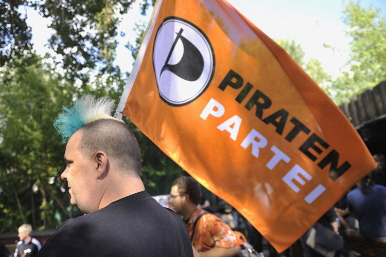 A member of Germany's Pirate Party holds a flag of the party (AP/Gero Breloer)