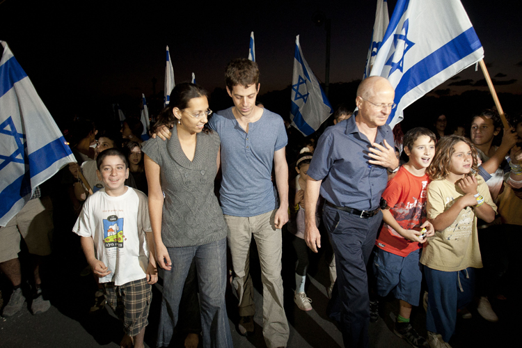 Noam Schalit, right, Yoel Schalit and Yaara Winkler, father and brother of captured Israeli soldier Gilad Schalit walk with family and friends to their home in Mitzpe Hila, northern Israel, Wednesday, Oct. 12, 2011. (AP)