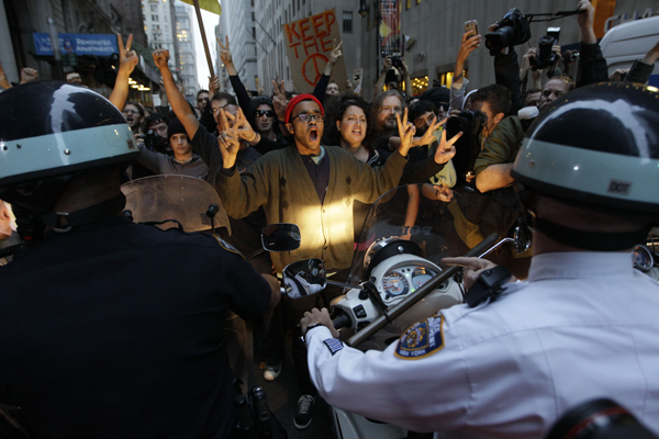 Demonstrator affiliated with the Occupy Wall Street protests confront New York City police officers as they march on the street in the Wall St. area, Friday, Oct. 14, 2011 in New York. (AP/Mary Altaffer)