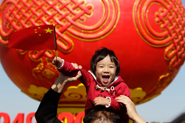 A child poses in front of a giant red lantern on display at Beijing's Tiananmen Square on China's National Day. (Reuters/Jason Lee)