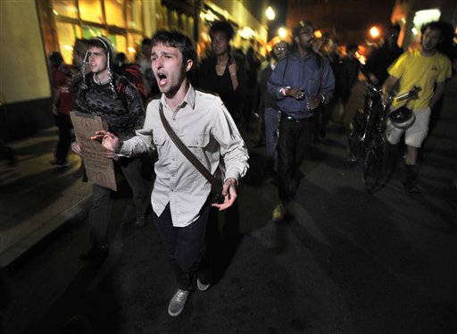 Demonstrators with "Occupy Boston" march toward  the police station where fellow demonstrators were brought after police arrested people sleeping in an expansion of the Occupy Boston tent village in Boston, in the early morning hours of Tuesday, Oct. 11, 2011. (AP/Josh Reynolds)