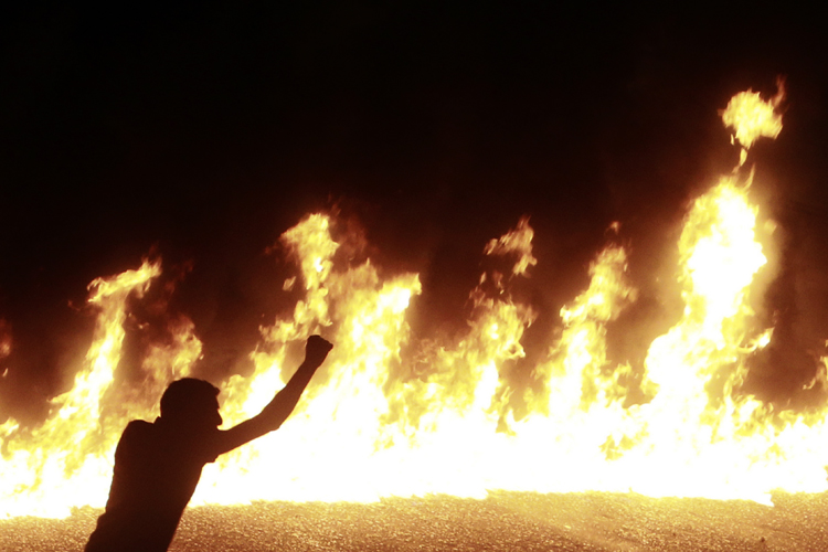 A protester stands near a line of fire during a demonstration in Cairo October 9, 2011. (Amr Dalsh / Reuters)