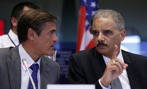 Spanish MEP Juan Fernandez Aguilar, left, looks on as United States Attorney General Eric Holder, right, speaks during a session at the European Parliament in Brussels on Tuesday, Sept. 20, 2011. (AP/Virginia Mayo)