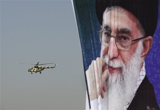 A police helicopter flies behind a poster of Iranian supreme leader Ayatollah Ali Khamenei during an exercise commemorating "Police Week", in downtown Tehran, Iran, Friday, Oct. 7, 2011. (AP Photo/Vahid Salemi)