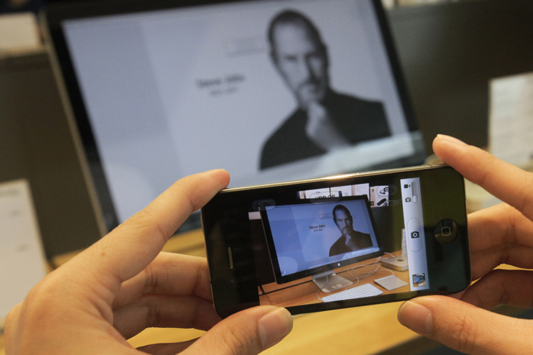 A man uses his iPhone to photograph image of Steve Jobs (AP/Sakchai Lalit)