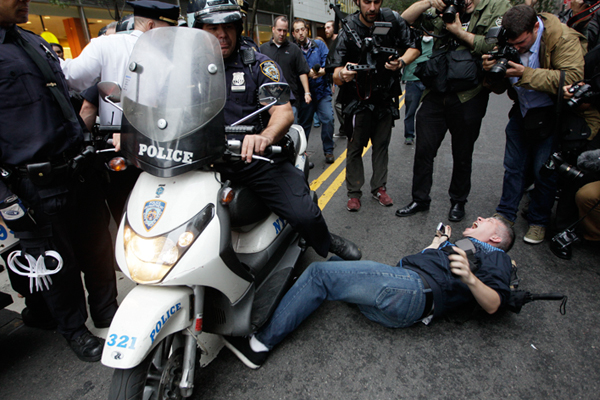A New York City police officer runs over a National Lawyers Guild observer as Occupy Wall Street demonstrators march through the streets near Wall Street, Friday, Oct. 14, 2011, in New York. (AP/Mary Altaffer)