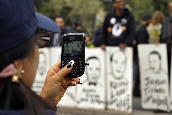 A woman takes pictures with her mobile phone at an Occupy Wall Street protest in Union Square in New York October 22, 2011 (Reuters/Eduardo Munoz)