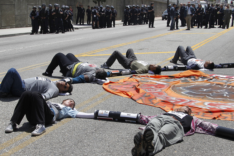 Protesters against Arizona's anti-immigration law SB 1070 lie on a street with their hands linked together. (Fred Prouser / Reuters)