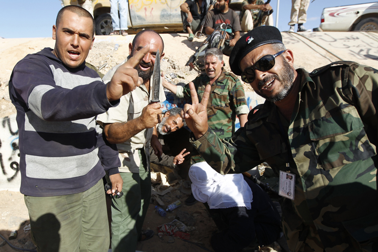 Anti-Gaddafi fighters celebrate at the drain where Muammar Gaddafi was hiding before he was captured in Sirte October 20, 2011. (Thaier Al-sudani / Reuters)