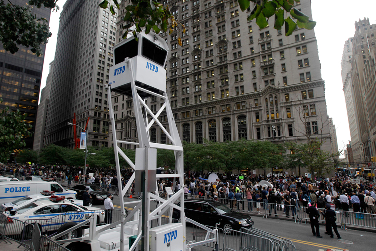 A New York Police Department guard tower looms over the Occupy Wall Street protest encampment at Zuccotti Park in New York (Kathy Willens/AP)