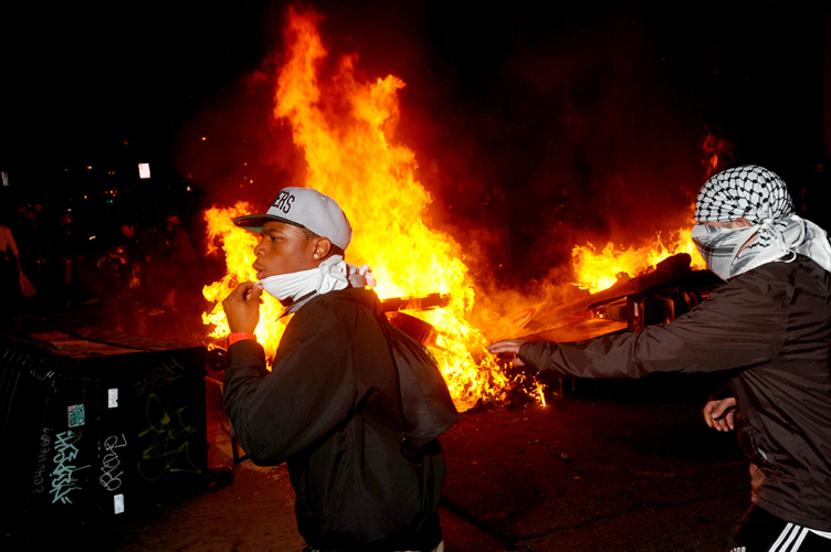 Occupy Oakland protesters pass a burning garbage heap during a confrontation with police on Thursday, Nov. 3, 2011, in Oakland, Calif. (AP/Noah Berger)