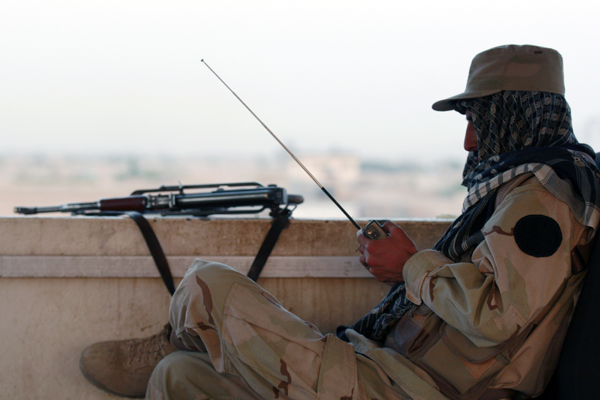 A private security organization contractor listens to a radio during his duty at guard tower in Camp Nathan Smith in Kandahar City (Nikola Solic / Reuters)