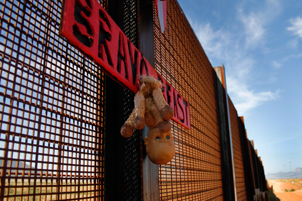 A toy doll hangs from the U.S. and Mexico border fence in Naco, Arizona September 7, 2011 (Reuters/Joshua Lott)