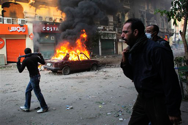 Protesters move away from tear gas fired by Egyptian riot police during clashes near Tahrir Square in Cairo on Monday. (AP/Tara Todras-Whitehill)
