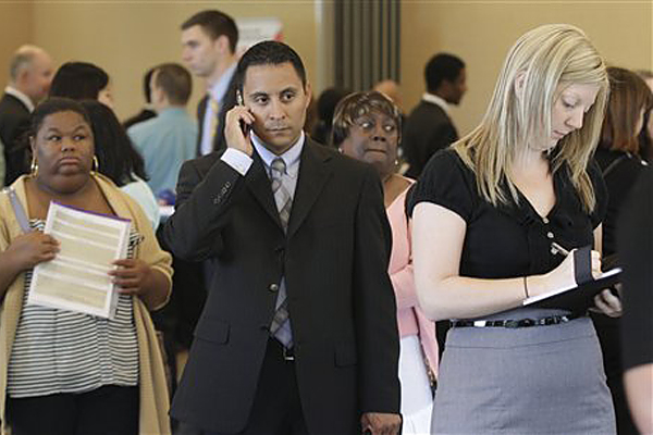 Nichole Smith, left, Lorenzo Ortiz, center, and Annelie Ingvarsson, right, wait in line to talk to potential employers during a National Career Fairs job fair, in Bellevue, Wash. (Ted S. Warren/AP)