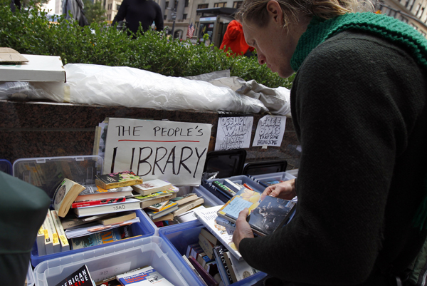A demonstrator browses books at the library of the Occupy Wall Street protesters' camp at Zuccotti Park in lower Manhattan in New York October 3, 2011. (Mike Segar / Reuters)