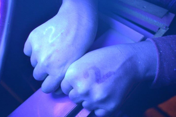 An Occupy Montreal protester's hand is shown under UV light after being marked by police. (Nina Haigh/Facebook)