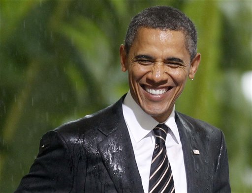 President Barack Obama smiles in the rain as he and French President Nicolas Sarkozy attend an event honoring the alliance between the United States and France and their efforts in Libya , Friday, Nov. 4, 2011, at Cannes City Hall, after the G20 Summit in Cannes, France. (AP Photo/Charles Dharapak) (AP)