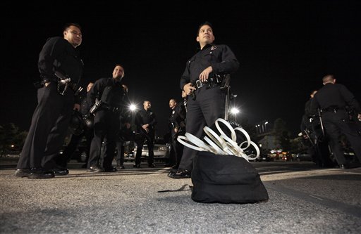 Los Angeles police officers stand by a sack containing wrist restraints late Tuesday, as they prepare to evict protesters from the Occupy Los Angeles encampment outside City Hall. (AP/Lucy Nicholson)