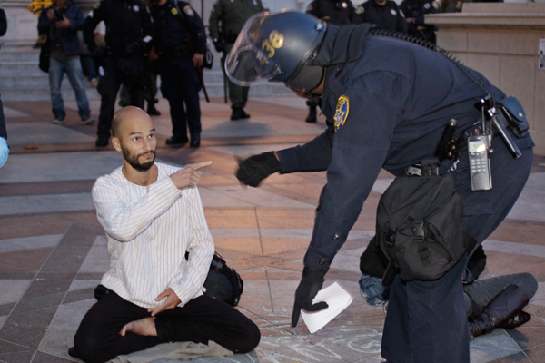 A policeman talks to a demonstrator as police break up an Occupy Wall Street encampment in Oakland on Monday. (AP/Paul Sancya)