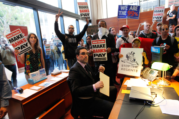 A banker is surrounded by Occupy San Francisco protesters who took over a Bank of America branch on Nov. 16. (Reuters/Robert Galbraith)
