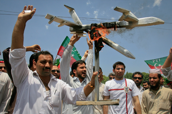 Protesters hold up a burning mock drone aircraft during a rally against drone attacks in Pakistan. (Reuters/K. Pervez)