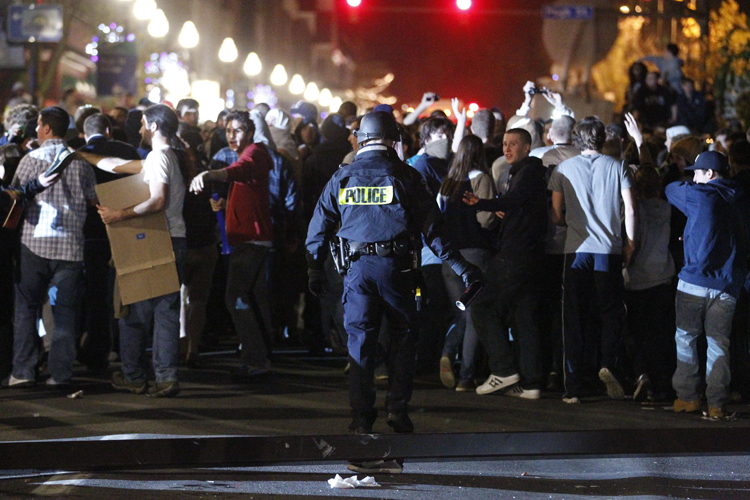 Police hold back students after they reacted off campus Nov. 10, 2011, in State College, Pa., to firing of football coach Joe Paterno. (AP/Matt Rourke)