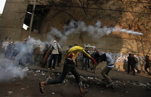 A protester throws a tear gas canister away during clashes with the Egyptian riot police near Tahrir square in Cairo, Egypt, Tuesday, Nov. 22, 2011 (AP Photo/Khalil Hamra)