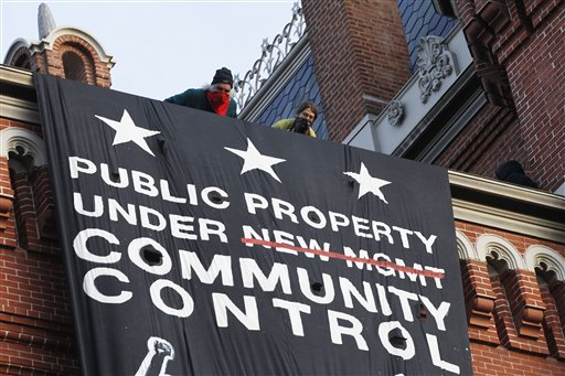 A group of protesters inspired by Occupy D.C. protest hang a banner on Franklin School building, in Washington, Saturday, Nov., 19, 2011 (AP Photo/Pablo Martinez Monsivais)