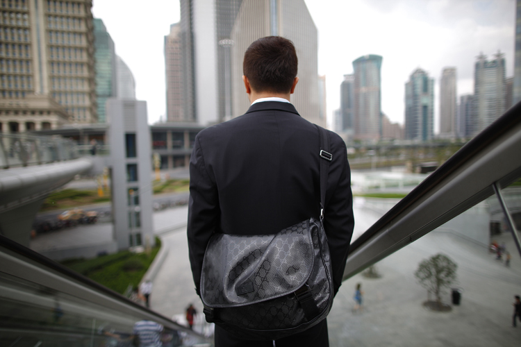 A business man rides an escalator in the financial district of Pudong in Shanghai (Aly Song / Reuters)
