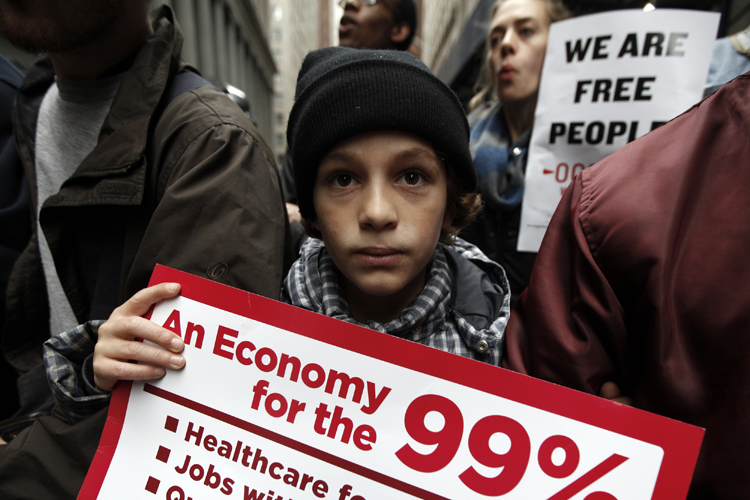 An Occupy Wall Street demonstrator holds a sign during what protest organizers call a "Day of Action" in New York November 17, 2011. (Brendan Mcdermid / Reuters)
