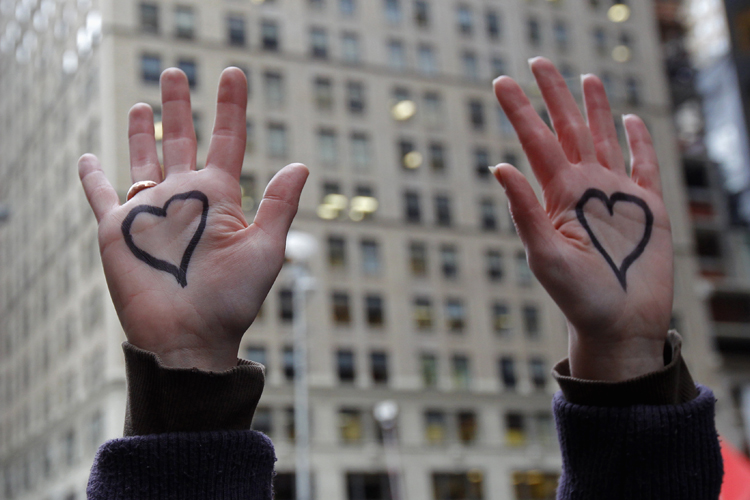 An Occupy Wall Street demonstrator raises her hands painted with hearts in New York (Mike Segar / Reuters)