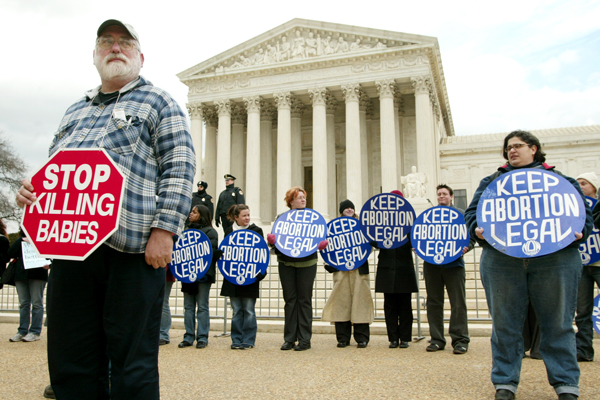 Pro-life and Pro-Choice demonstrators stand in front of the Supreme Court during a pro-life rally in Washington (Reuters)
