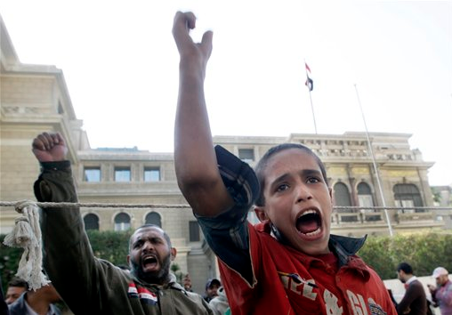 An Egyptian boy shouts slogans during a protest demanding the ruling military council to step down in front of the cabinet office in Cairo, Egypt, Sunday, Dec. 4, 2011. (AP Photo/Amr Nabil)