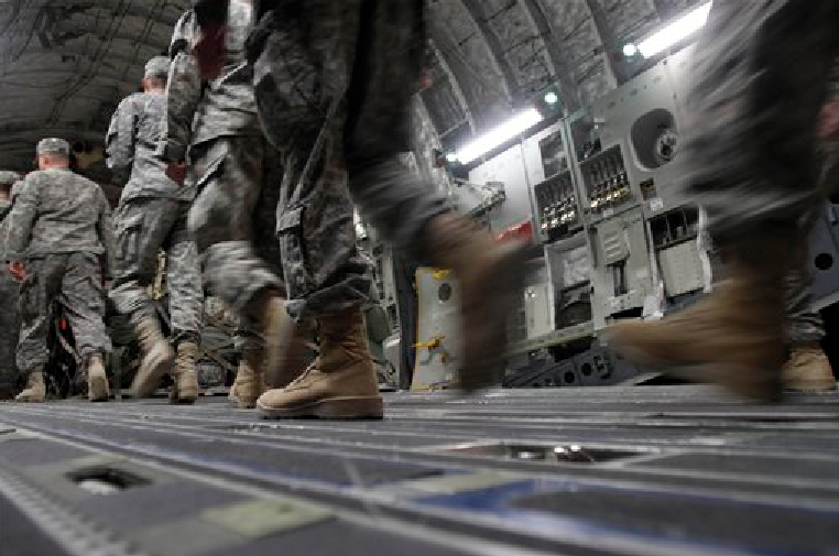 U.S. Army soldiers from the 25th Infantry Division board a plane at Camp Adder moments before the unit leaves Iraq. (AP Photo/Maya Alleruzzo)