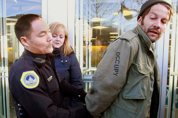 A protester is arrested for blocking the entrance to Republican presidential candidate Mitt Romney's local campaign office during an Occupy The Caucus demonstration in Des Moines, Iowa. (AP/J. David Ake)