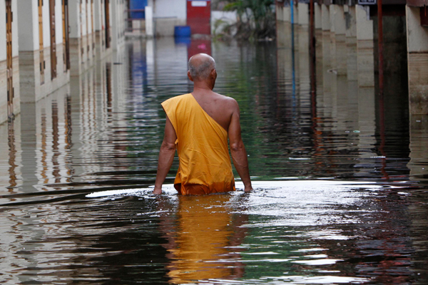 A Buddhist monk wades through a flooded temple in Bangkok. (Reuters/Sukree Sukplang)
