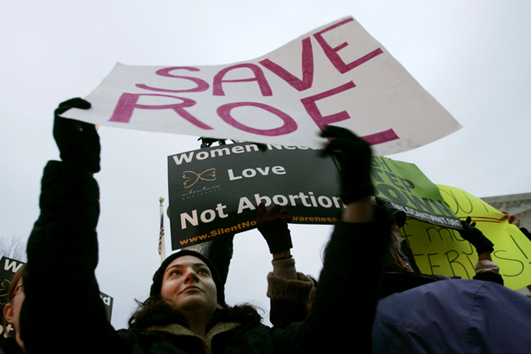 Trish Calamari, raises her sign to block the signs of anti-abortion protesters in front of the Supreme Court Building in Washington. (AP)