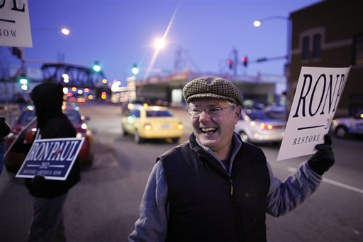 Chris Noth, a Ron Paul supporter, holds up a sign outside Mitt Romney's campaign stop in Davenport, Iowa, Dec. 27, 2011. (AP Photo/Chris Carlson)