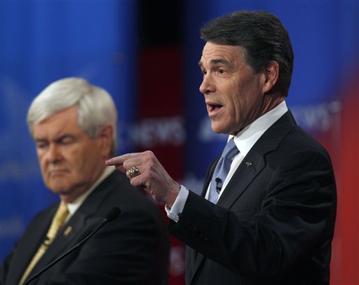 Texas Gov. Rick Perry answers a question as former House Speaker Newt Gingrich listens in the background during a Republican presidential candidate debate at the Capitol Center for the Arts in Concord, N.H., Sunday, Jan. 8, 2012. (AP Photo/Charles Krupa) (AP)