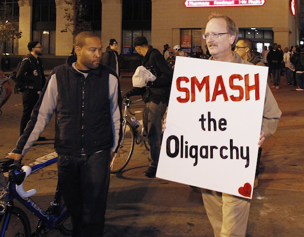 A demonstrator holds up his sign as he marches to City Hall plaza in Oakland, Calif. November 14, 2011 (REUTERS/Kimberly White)