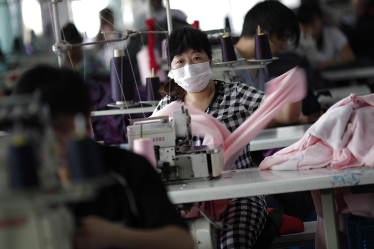 An employee works at the Yiwu Lianfa clothing factory in Yiwu, Zhejiang province, June 8, 2011 (Carlos Barria / Reuters)
