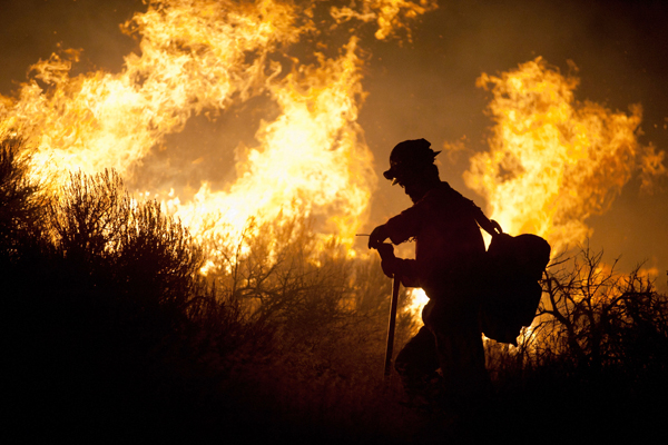 A crew member from the Nevada Department of Forestry works to control the Washoe Drive fire in Washoe City, Nev. on January 19, 2012 (Reuters/James Glover II)